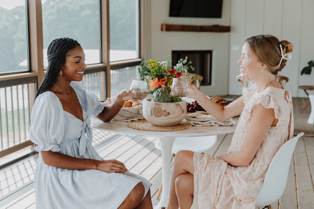 models sitting at a table having brunch wearing a pretty babydoll dress with tie front detail and a floral ruffle sleeve maxi dress and hair clip | Hudson Blake lifestyle and home | shophudsonblake.com